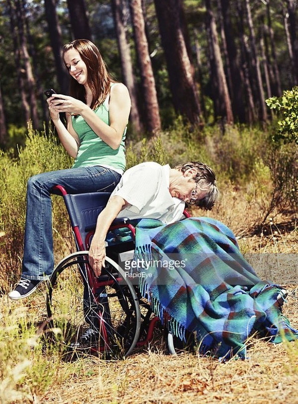 WTF stock photos dead man in a wheelchair while young woman texts