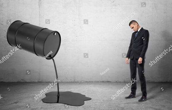 WTF stock photos oil dripping from barrel man looks on