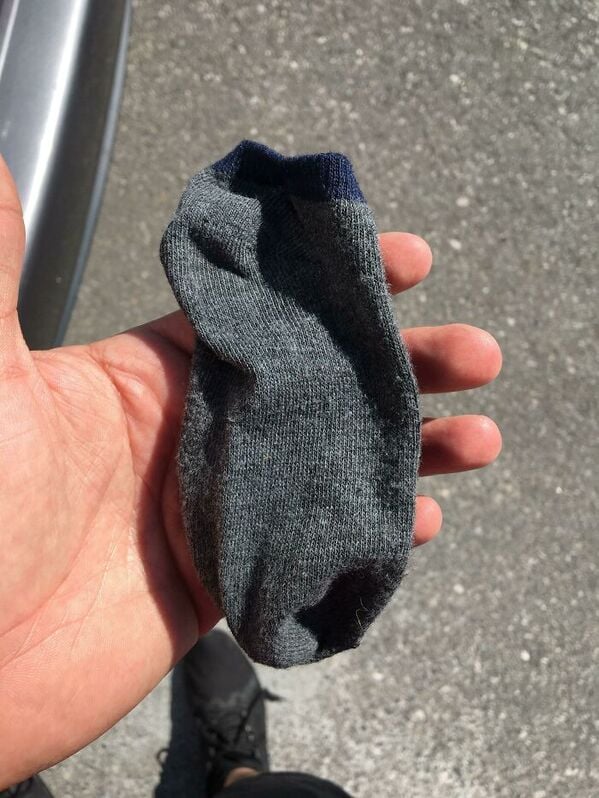 man holding a sock in a parking lot, funny people having a worse day, well that sucks