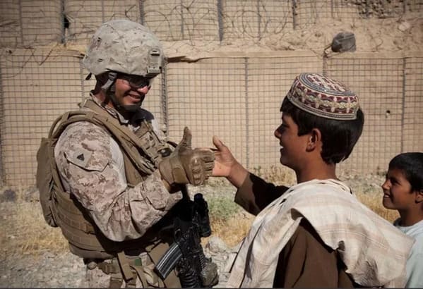 American soldier thumb wrestling a kid in Afghanistan, Funny Fake history photos, r fakehistoryporn, facts about history that are not true, false textbook photos, historical pics with funny captions, lol, jokes, old photos with hilarious explanations, funny pics